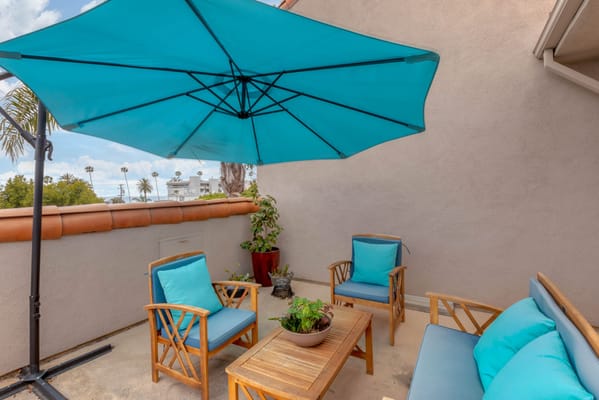 Outdoor seating area with a blue umbrella and chairs