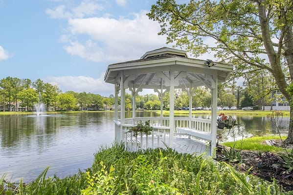 Gazebo by a serene lake in a landscaped area