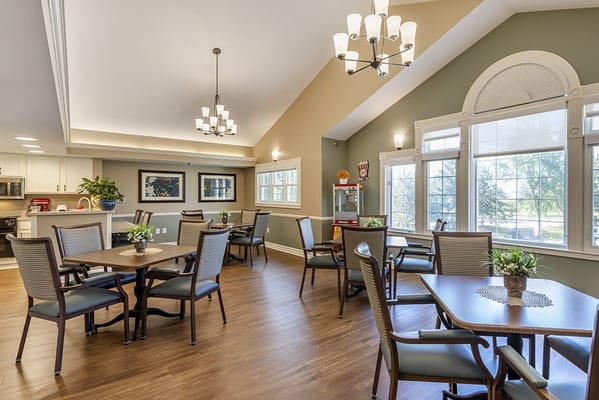 Bright common area with tables and chairs for residents