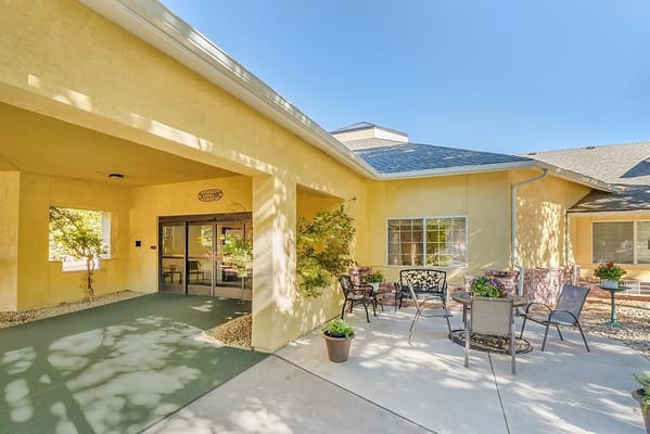 Exterior view of a senior living facility with outdoor seating