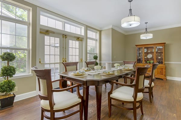 Bright, nicely set dining room with a table and chairs