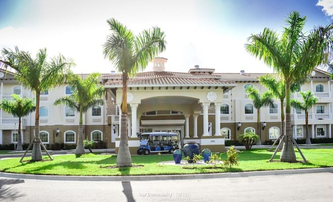 Exterior view of the facility with palm trees and a golf cart