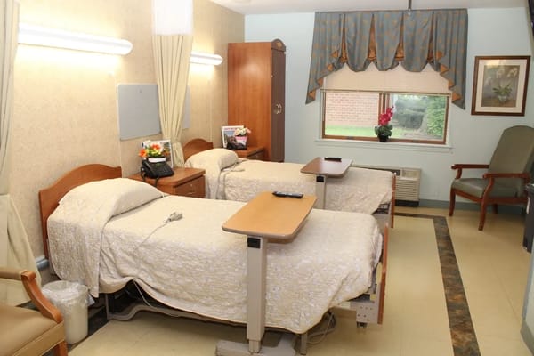 A cozy resident room with two beds and furnishings