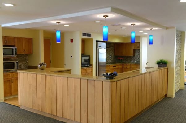 Bright kitchen area with wooden cabinetry and blue pendant lights