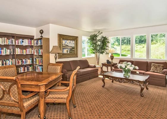 Comfortable living room with bookshelves and flower arrangements