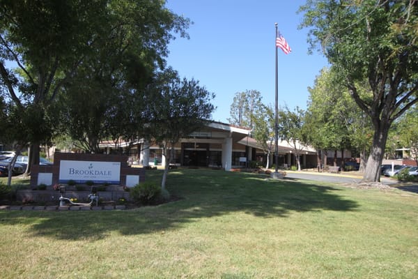 Exterior view of Brookdale San Jose with landscaping and flag