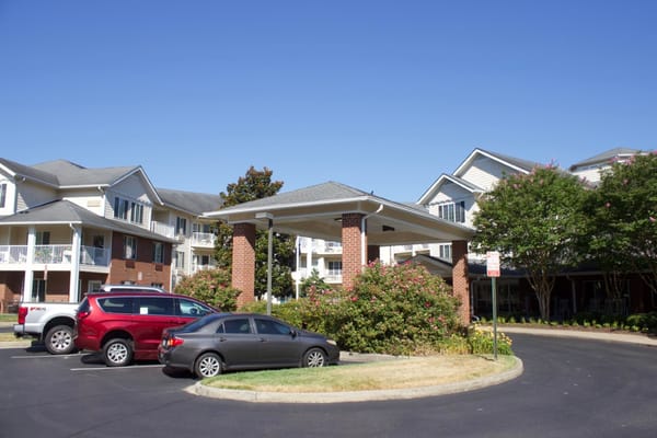 Building exterior view with parking area and landscaped entrance