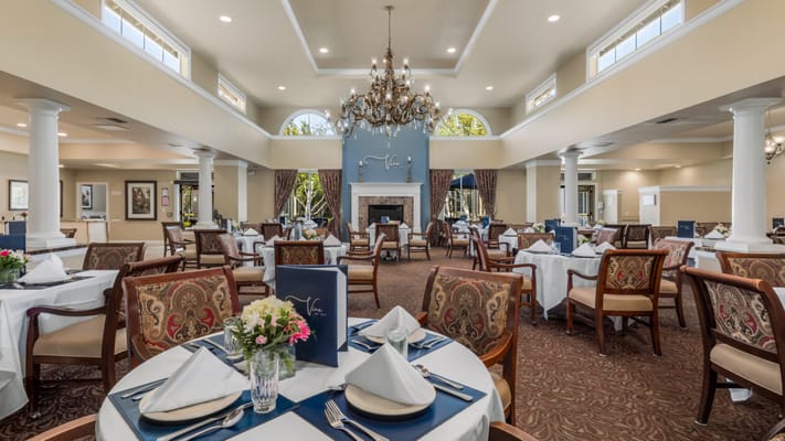 Elegant dining room setup with chandeliers and floral arrangements