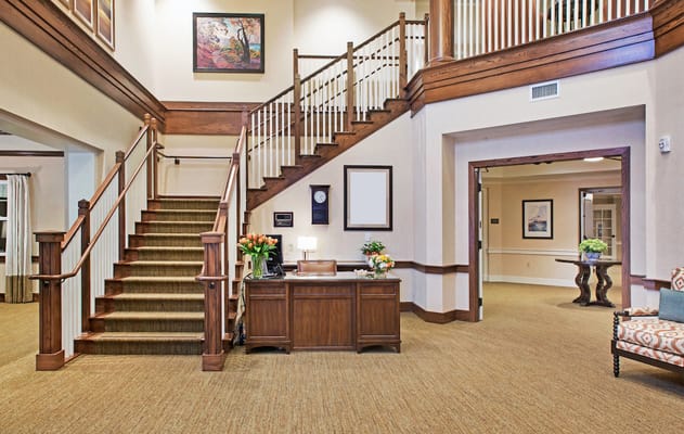 Bright interior lobby with a staircase and reception area