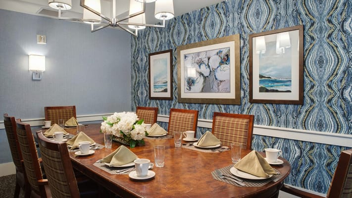 Elegant dining room set with a large table, floral centerpiece, and table settings