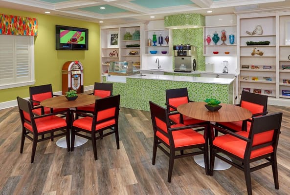 Cozy lounge area with red and black chairs and a green bar.