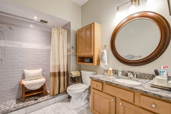 Modern bathroom featuring a shower, sink, and wooden vanity.