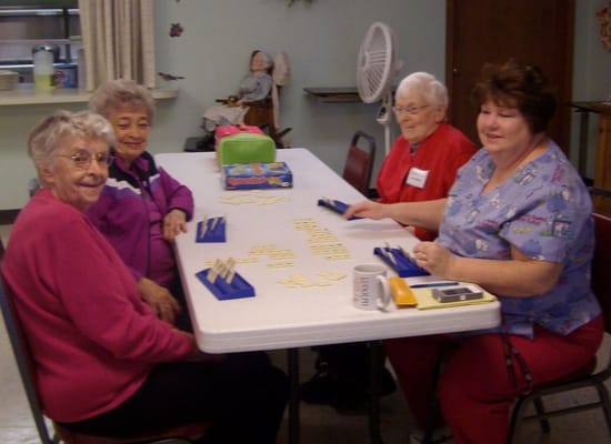 Residents engaged in a game at a communal table
