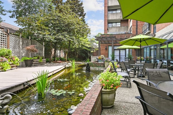 Outdoor space with a pond and seating areas