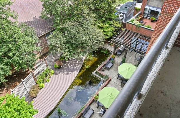 Aerial view of landscaped outdoor space with seating and pond