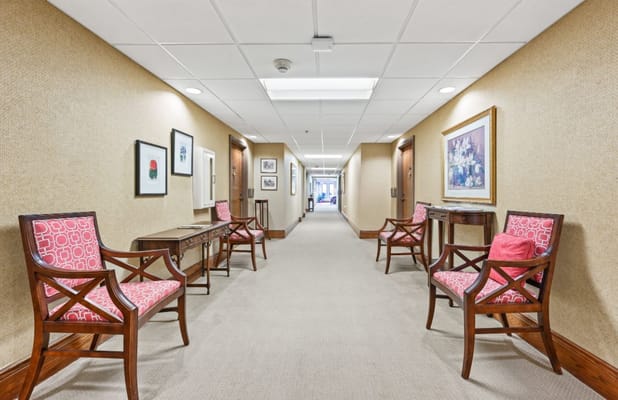 Well-lit hallway with chairs and artwork