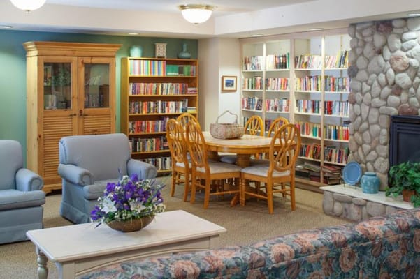 Cozy common area with bookshelves and seating at Monroe House