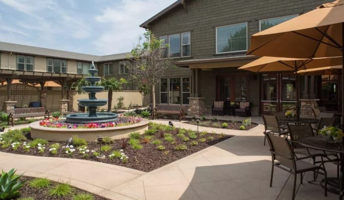 A beautifully landscaped outdoor space with a fountain and seating.