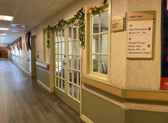 Interior hallway featuring garden room entrance and directory sign at Pelican Pointe