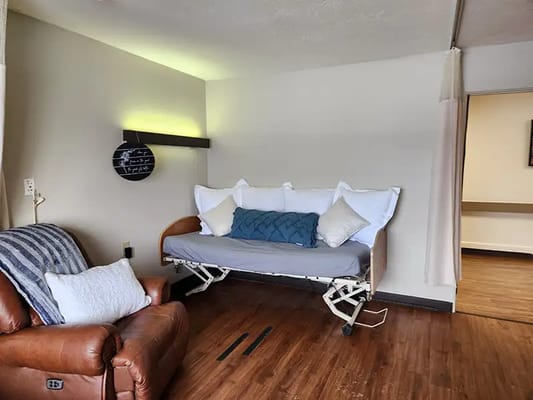 A well-furnished resident room with a hospital bed