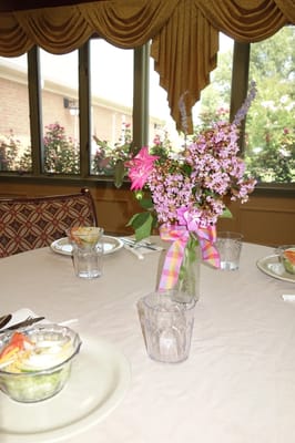 Dining table set with flowers and meals.