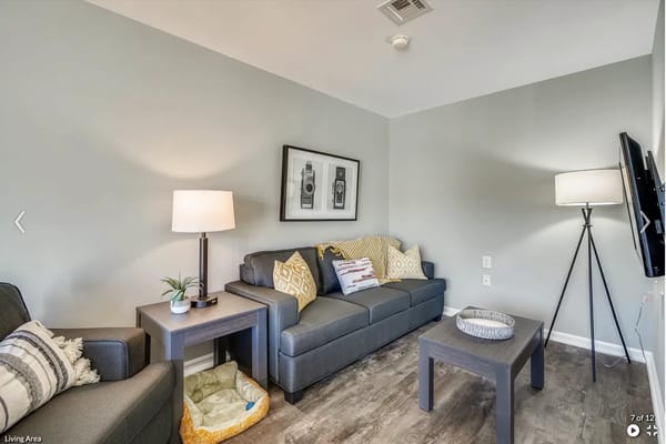 Living area featuring a couch, table, and lamp.