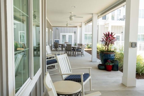 Porch with seating area and plants at Seagrass Village.