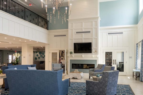 Bright and welcoming lobby with blue chairs and a fireplace