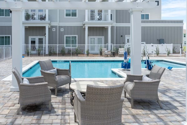 Outdoor pool area with lounge chairs and tables