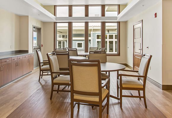 Light-filled common area with chairs and tables.