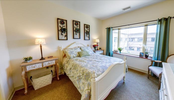 A bright and inviting bedroom with a bed, side tables, and a window.