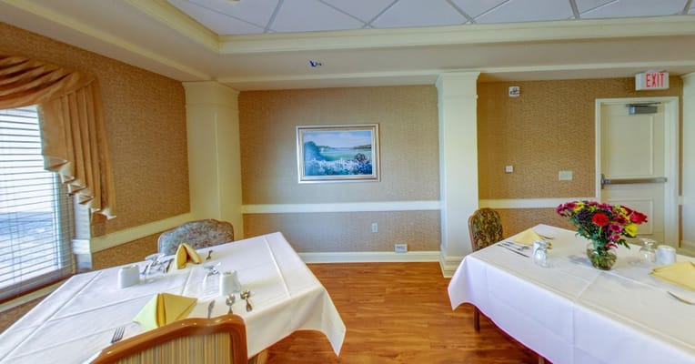 Elegant dining room setup with tables and flower centerpiece