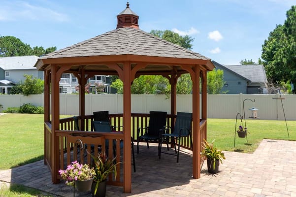 Outdoor gazebo with seating surrounded by greenery