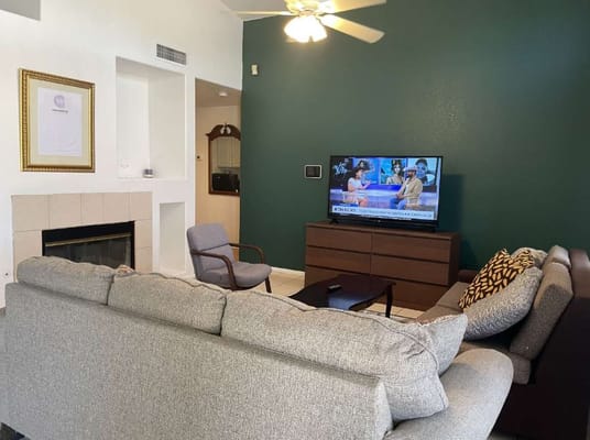 A cozy living room featuring a couch, chair, and television