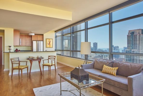 Modern living room with dining area and city skyline view.