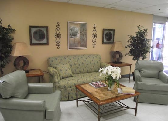 Comfortable living room with a sofa, chairs, and decorative plants