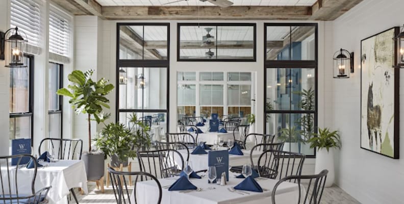 Modern dining room setup with plants and large windows