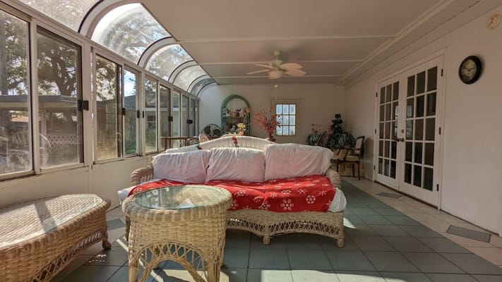 Bright sunroom with comfortable seating and decor