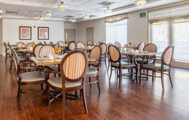Brightly lit dining room with tables set for meals