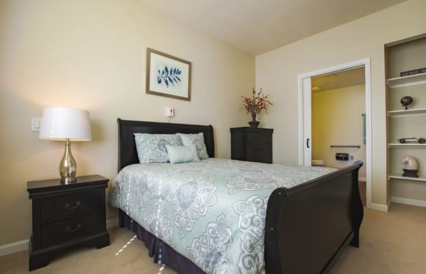 A well-furnished bedroom with a double bed and bedside table.