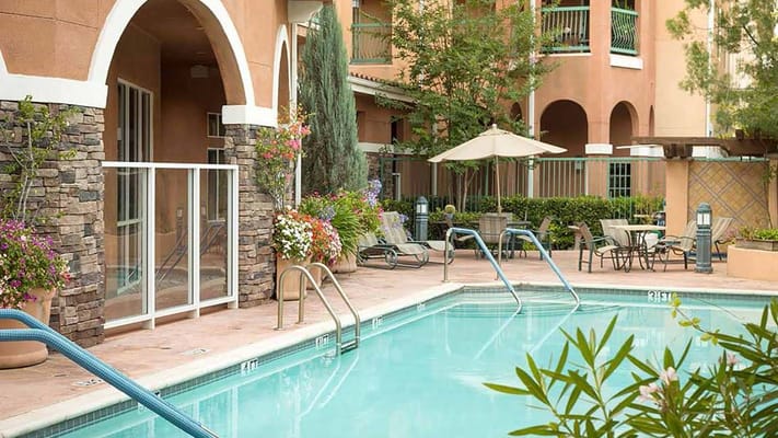 Outdoor pool area with lounge chairs and umbrellas