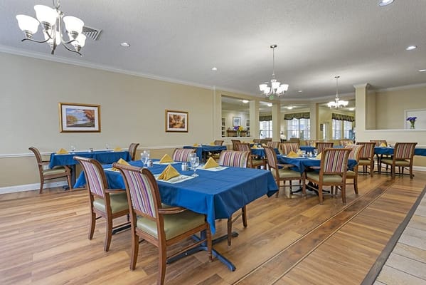 A dining room set for a meal with blue tablecloths
