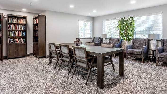 Cozy lounge area with bookshelves and seating at Holiday Cedar Ridge.
