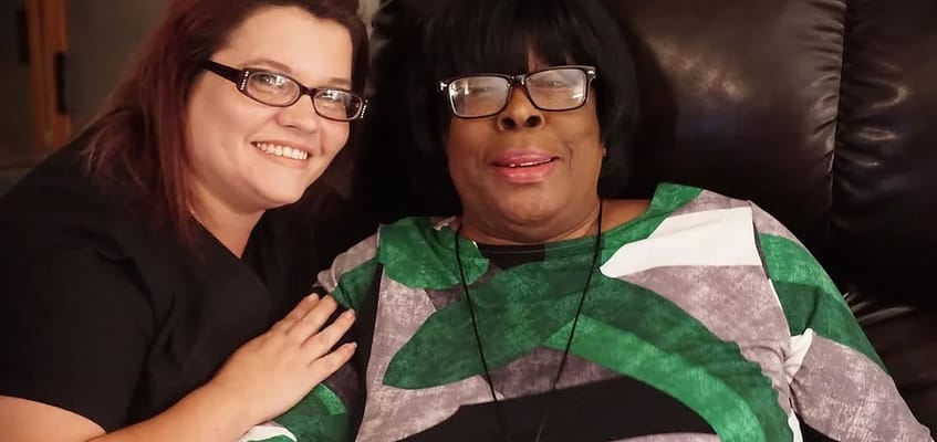 Staff member smiling with a resident in a cozy setting