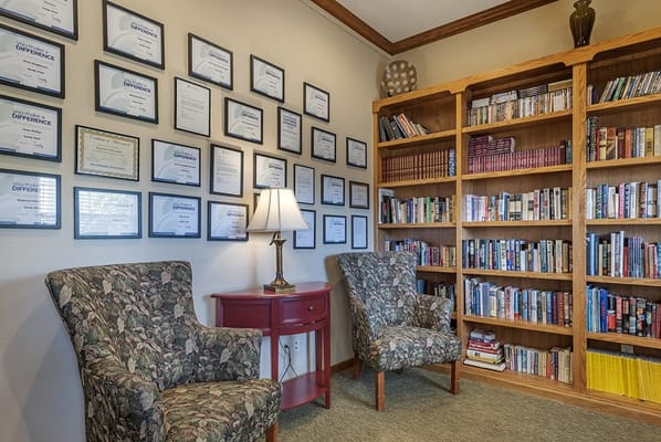 Cozy reading nook with bookshelves and certificates