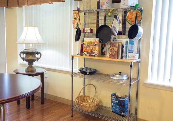Shelving unit with cooking supplies in a common area