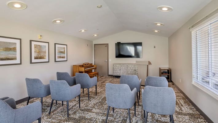 Bright common area with chairs and a piano