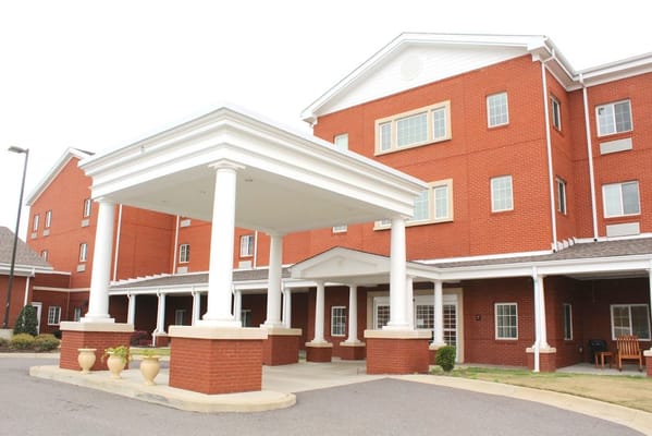 Entrance of a nursing home facility with columns and brick facade