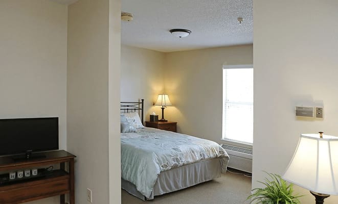 Private resident bedroom with bedding and furniture
