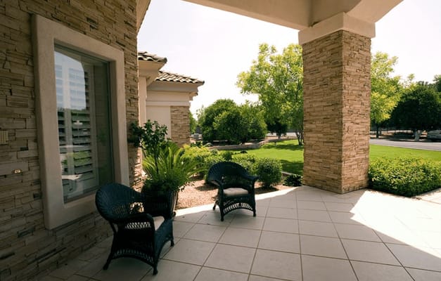 Outdoor seating area with chairs and greenery